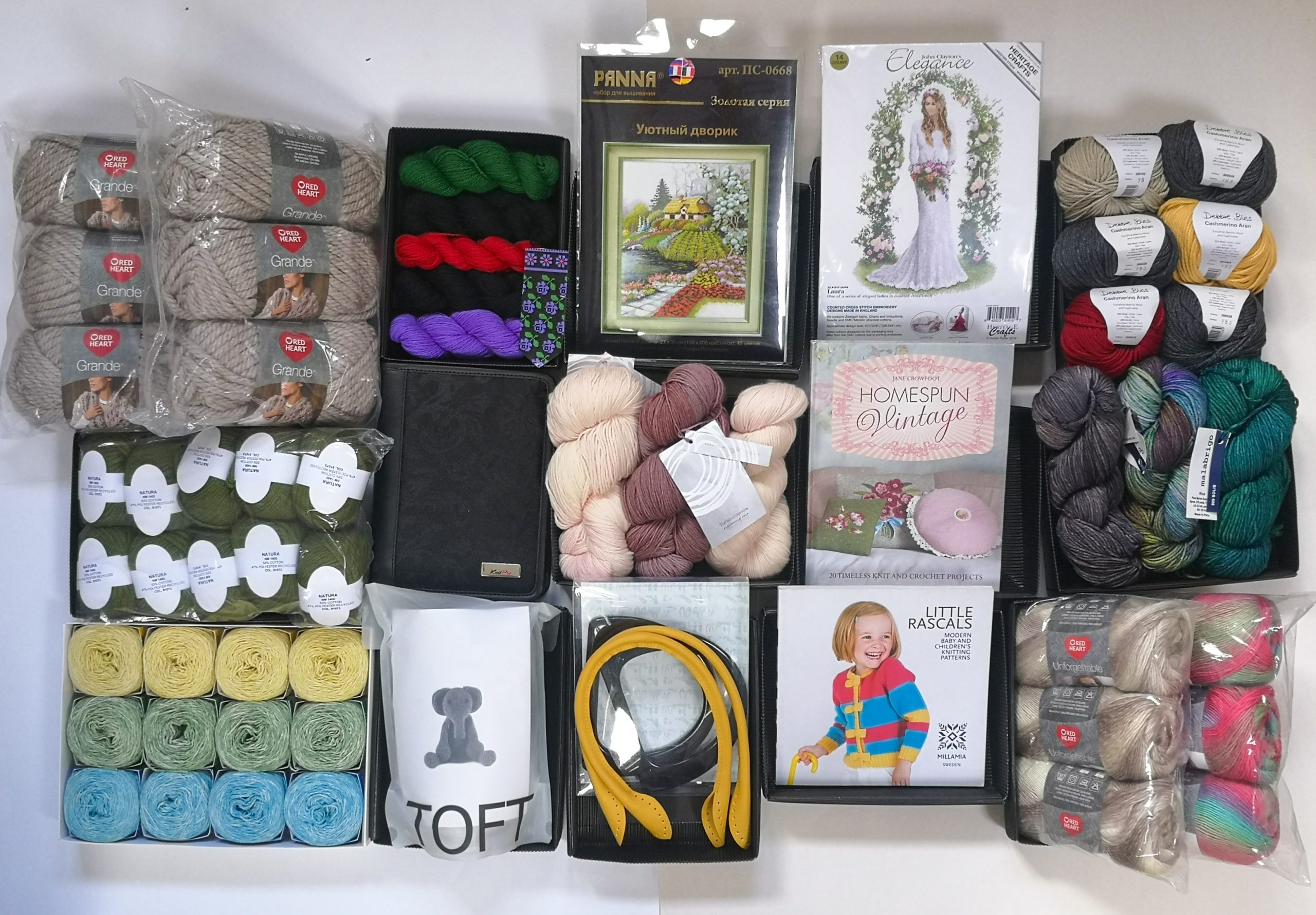 A picture taken from above of a variety of the potential prize you could receive in the Knit for Peace Lucky Dip: yarn, knitting supplies, embroidery kits and other crafting materials.