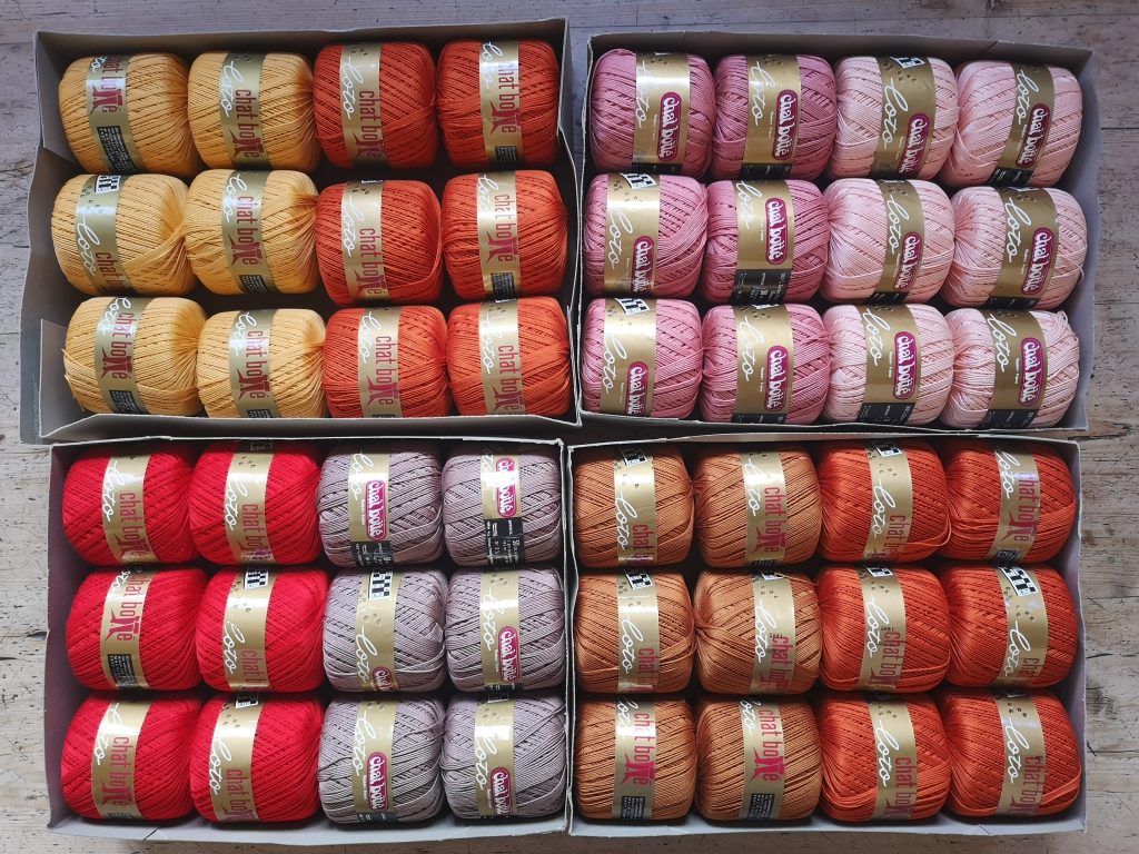 A picture of 48 balls of Chat Botté fine cotton yarn in a variety of colours